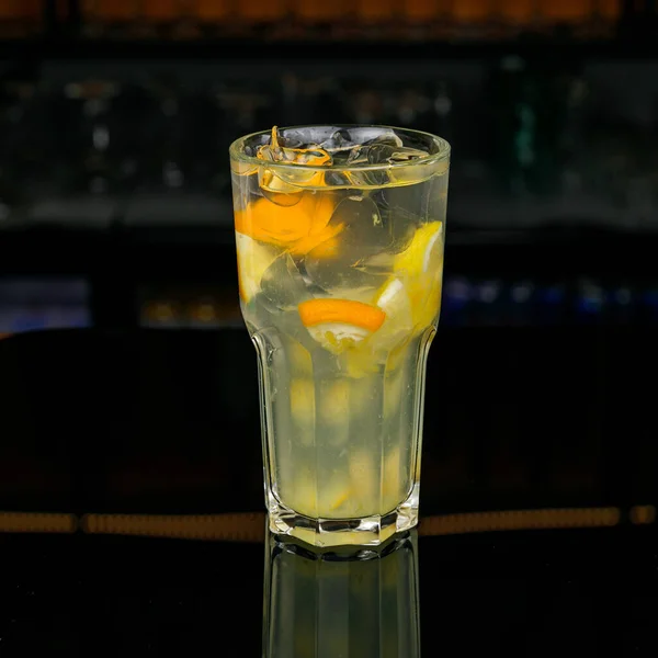 バーカウンターにレモンと氷のキューブを入れたフレッシュレモネードのグラス — ストック写真