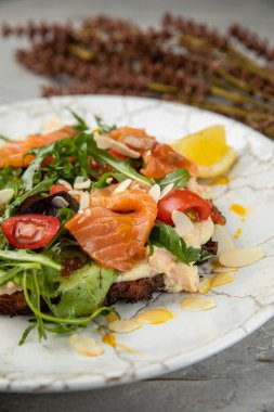 Somonlu salata, havyar, otlar, kirazlar. Lokantadaki beyaz taş bir masada.