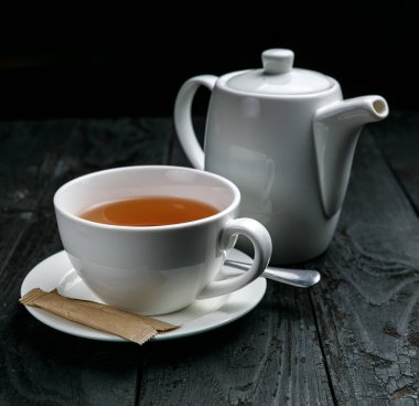 Bir fincan çay ve bir çaydanlık.