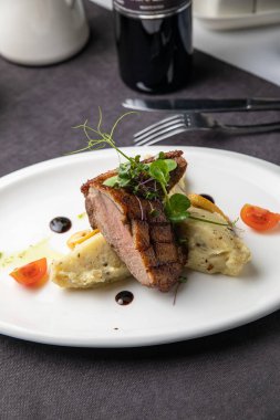 Sebzeli ızgara biftek ve beyaz tabakta baharat.