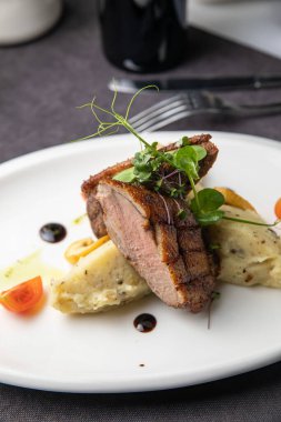 Sebzeli ızgara biftek ve beyaz tabakta baharat.