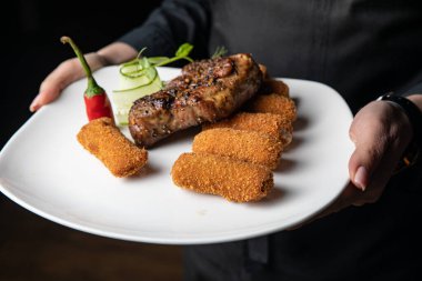 Sebzeli ızgara biftek ve beyaz tabakta baharat.