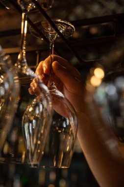 Barmen restoranda bardakları dolduruyor.