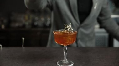 Barmen buzlu alkollü bir kokteyl hazırlar.