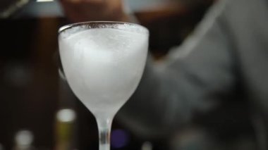 Barmen buzlu alkollü bir kokteyl hazırlar.