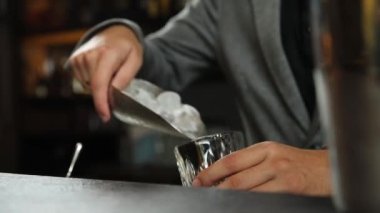 Barmen buzlu alkollü bir kokteyl hazırlar.
