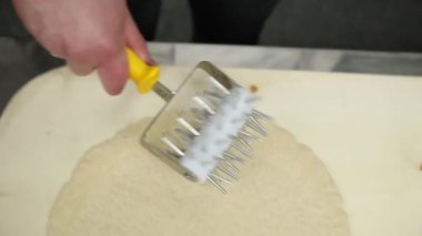 Şef sosisli ve peynirli pizza hazırlar. 