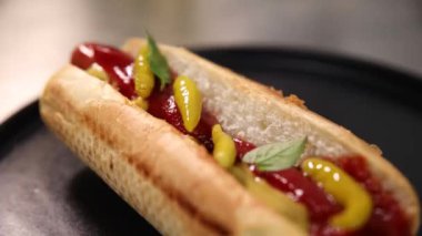 Şef ızgara sosisli sandviç hazırlıyor.