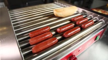 Şef ızgara sosisli sandviç hazırlıyor.