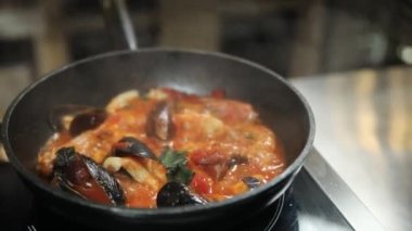 Şef mutfakta fesleğenli yeşil makarna hazırlıyor.