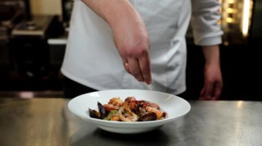 Şef mutfakta fesleğenli yeşil makarna hazırlıyor.