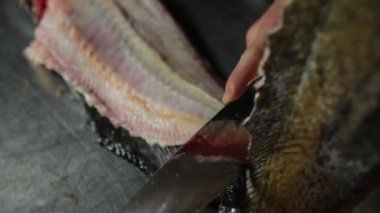 Şef büyük bir yayın balığı kesiyor. 