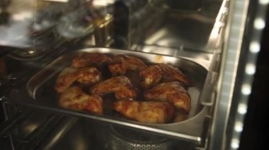 Şef mutfakta tavuk pişiriyor.