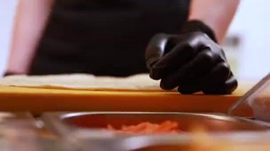 Şef mutfakta et ve sebzeli pide hazırlıyor.