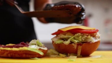 Şef mutfakta hamburger hazırlıyor.