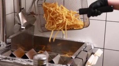 Şef mutfakta hamburger hazırlıyor.