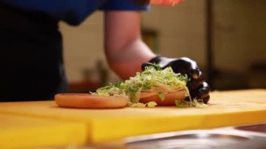 Şef mutfakta hamburger hazırlıyor.