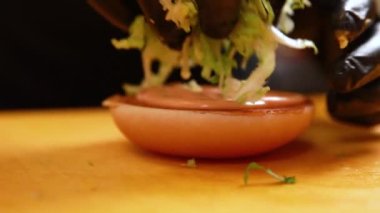 Şef mutfakta hamburger hazırlıyor.