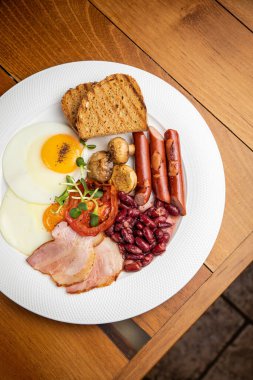 Restorandaki ahşap bir masada İngiliz kahvaltısı.