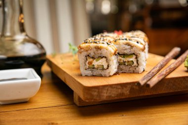 Japon mutfağı. Ahşap tabakta soslu rulo