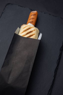 Siyah tahtada sosisli sandviç.