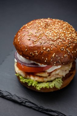Siyah ahşap arka planda kara tahtada hamburger.