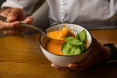 Tahta bir masada ıspanaklı ve sebzeli gazpacho.