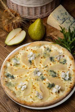 Armut ve Gorgonzola ile ahşap bir masada pizza.
