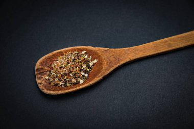 Koyu arkaplanda tuz ve baharatlı ahşap kaşık
