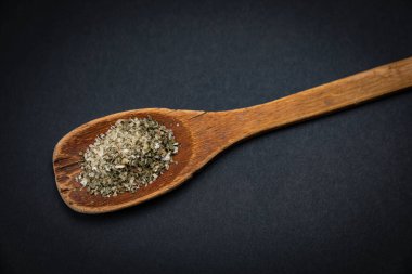 Koyu arkaplanda tuz ve baharatlı ahşap kaşık