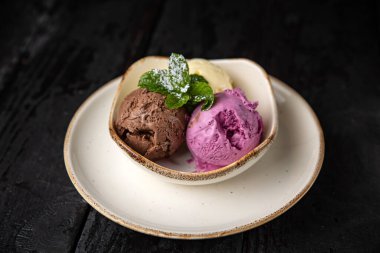 ice cream with chocolate and mint on a dark background.