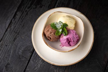 Çikolatalı dondurma ve ahşap arka planda nane şekeri..