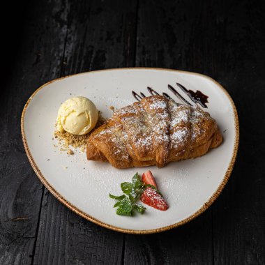 delicious baked pancakes with chocolate sauce on a wooden background