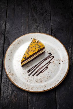 delicious chocolate cake with cream and nuts on a black plate