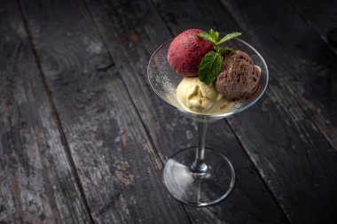 Çikolatalı dondurma ve ahşap arka planda nane şekeri..