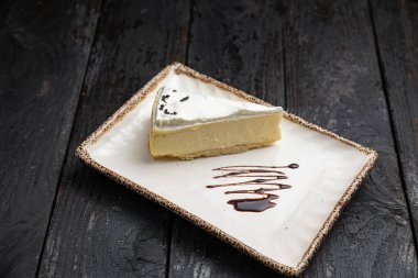 piece of cheesecake with cream and chocolate on a white plate