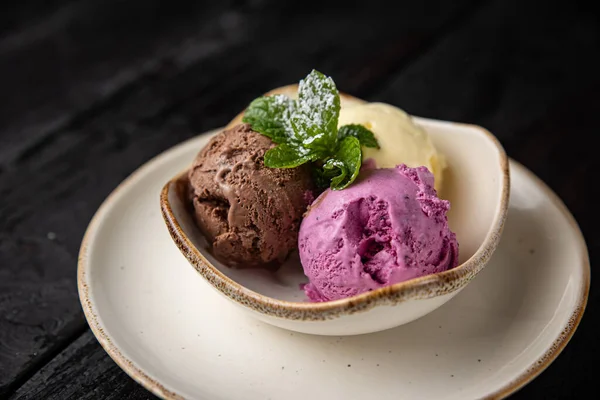 ice cream with chocolate and mint on a dark background.