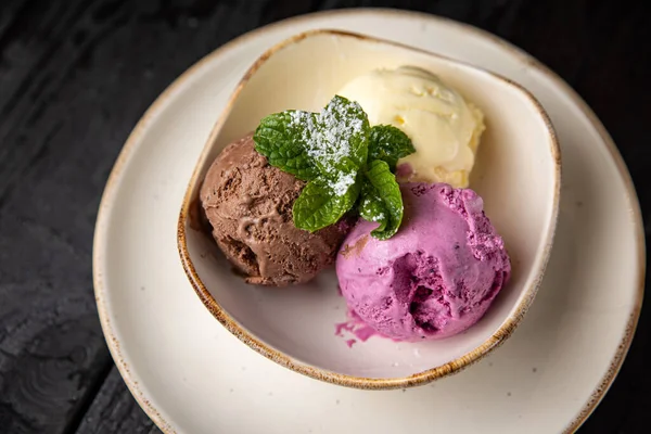 ice cream with chocolate and mint on a wooden background.