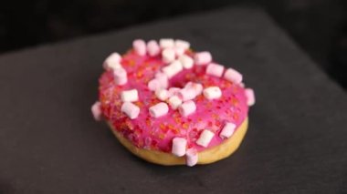 Beautiful doughnuts covered in chocolate glaze, sprinkles, marshmallows and chopped nuts