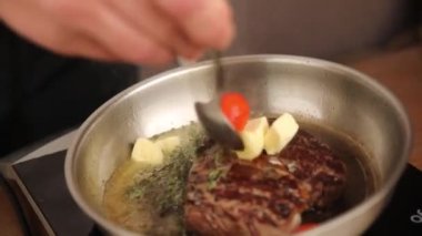 the chef cooks a steak in a frying pan