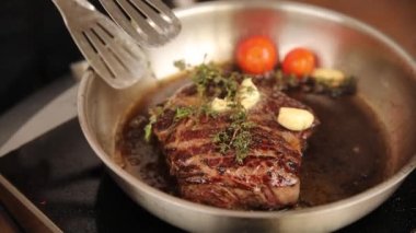 the chef cooks a steak in a frying pan
