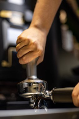 man pouring coffee from a grinder