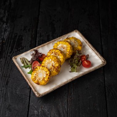 Koyu ahşap bir masada ızgara sebze yemek.