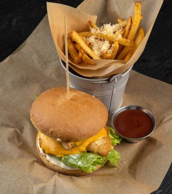 Tavuklu hamburger, domates ve ahşap zemin üzerinde soğan.