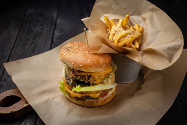 Tavuklu hamburger, domates ve ahşap zemin üzerinde soğan.