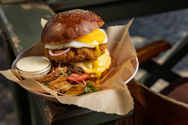 Tavuklu hamburger, peynir ve patates cipsi, yakın plan.