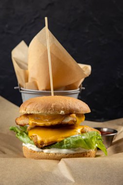 Tahta masada tavuk ve sebzeli lezzetli bir hamburger.