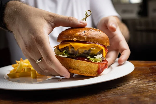 burger with chicken, tomato and onion on wooden background