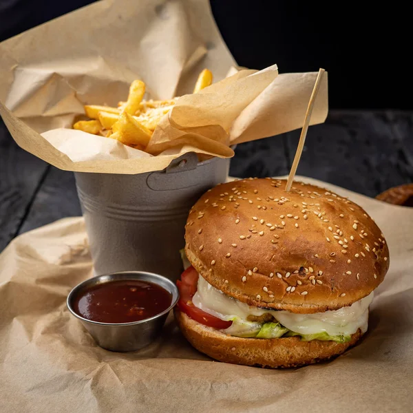 burger with chicken, tomato and onion on wooden background