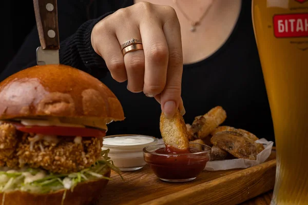 burger with chicken and vegetables on a black background